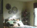 Three clocks above a bed